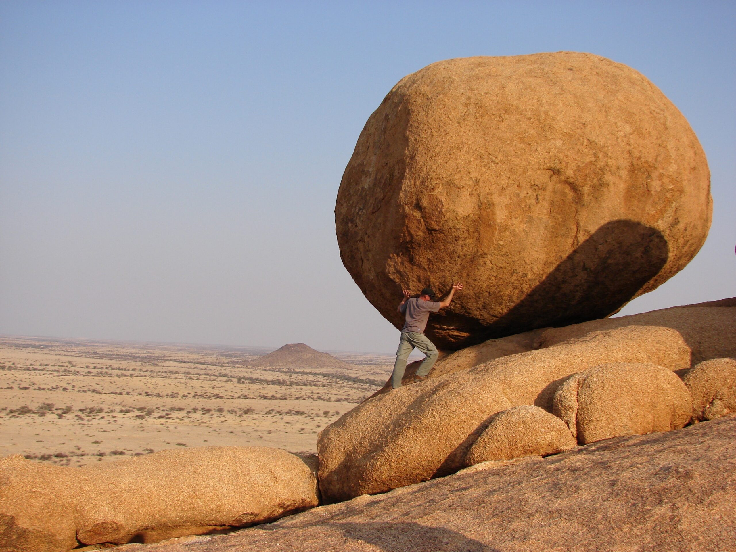 man pushing boulder Managing Change